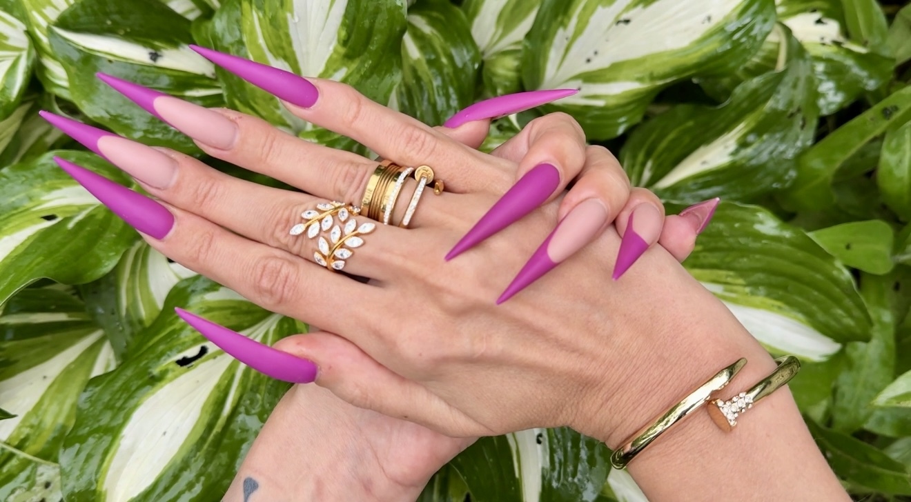 New purple color Long nails, sharp stilettos, palms, long fingers in the garden with flowers