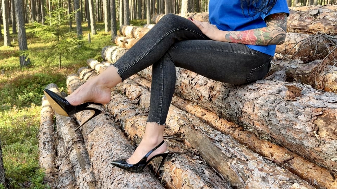 Black classic Stiletto High Heels with no back, 12 cm heels in the forest, deep in the sand